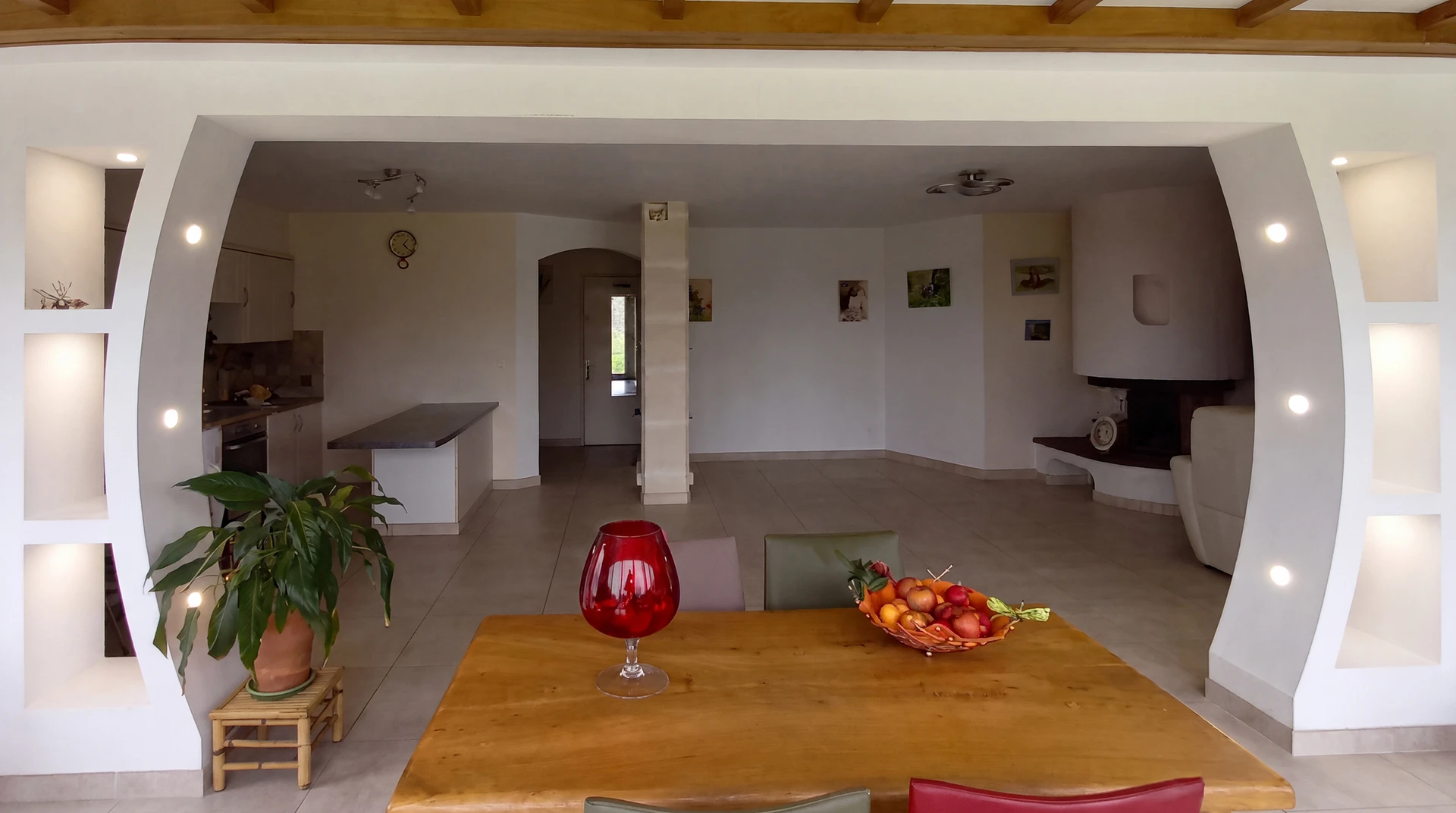 Intérieur d'une maison moderne ouverte, vue depuis une salle à manger vers un salon-cuisine