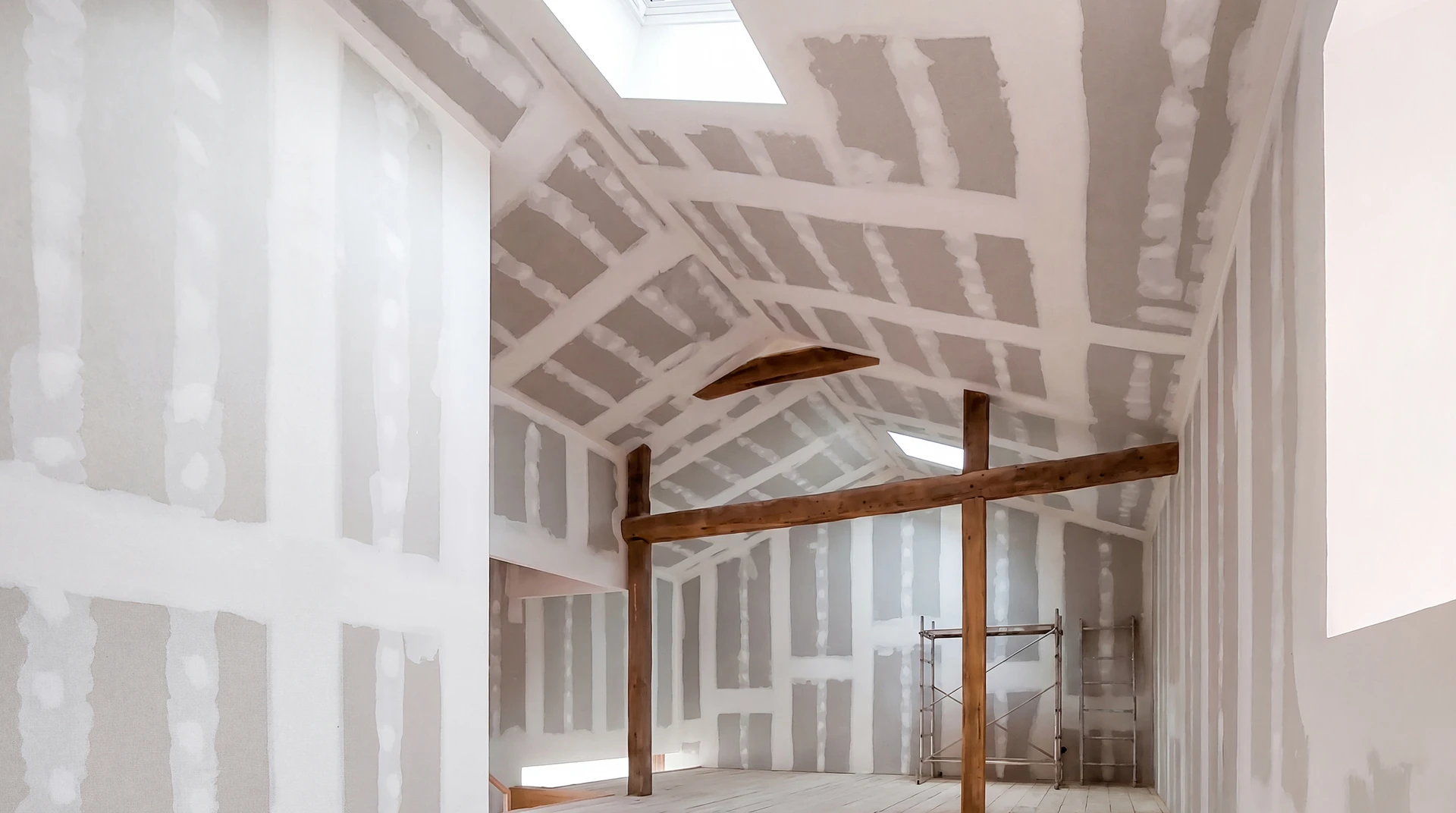 Ouvrier en bâtiment installant des plaques de plâtre sur ossature métallique