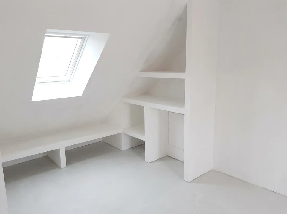 Intérieur en cours de rénovation, mur en pierres apparentes calcaires avec arc en plein cintre, encadrement de fenêtre en bois massif