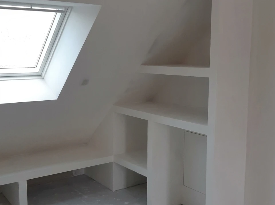Une personne en chemise rayée présente une maquette architecturale 3D d'un intérieur moderne avec cuisine équipée, salon et bureau