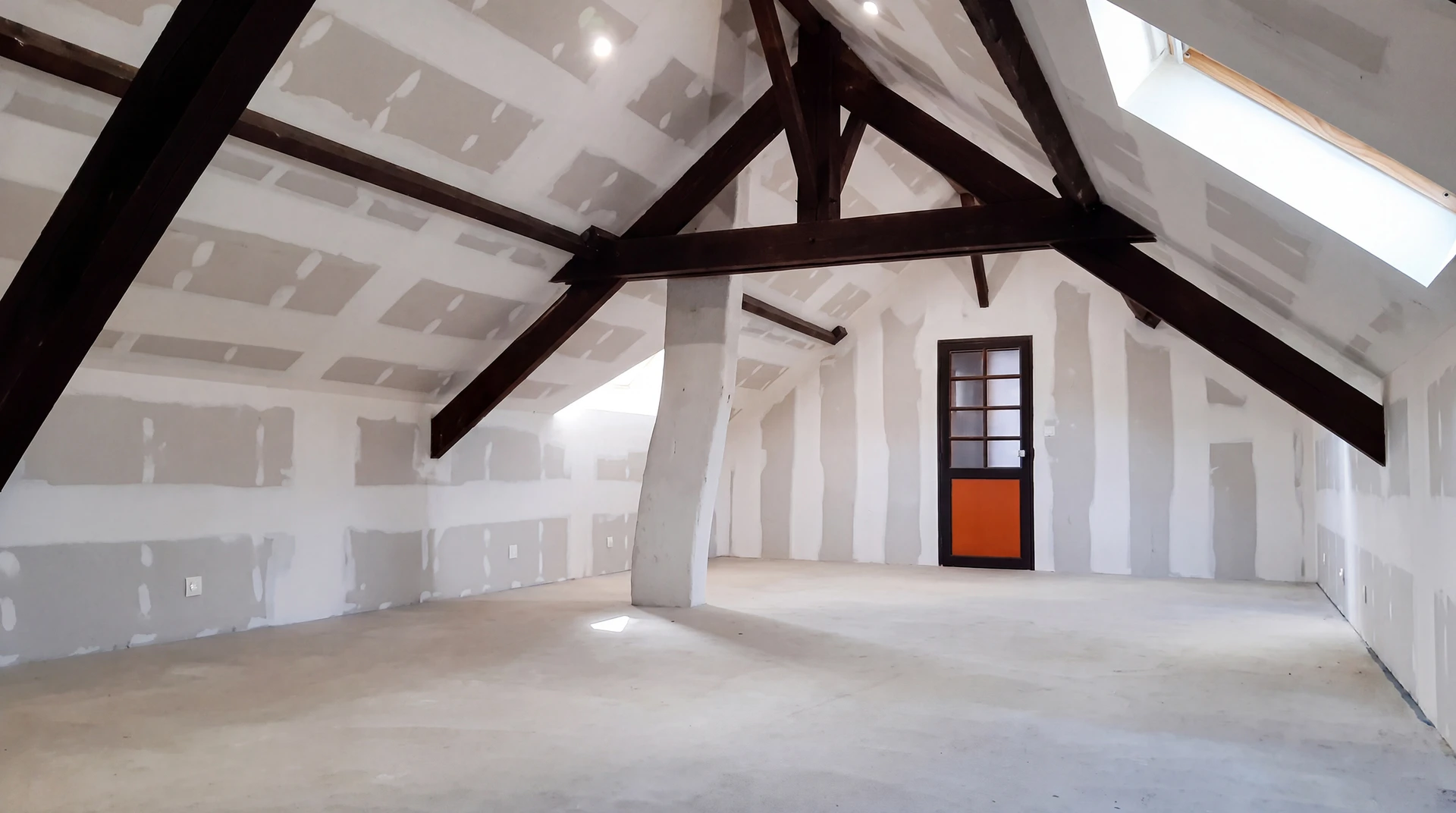 Ouvrier installant un plafond suspendu en plaques de plâtre dans un intérieur résidentiel